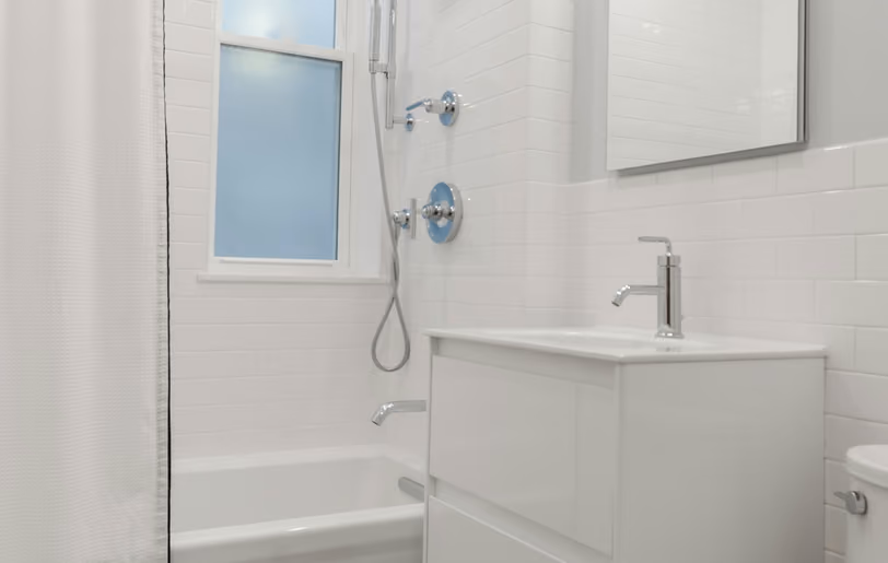 White tiled bathroom with a shower, bath and vanity